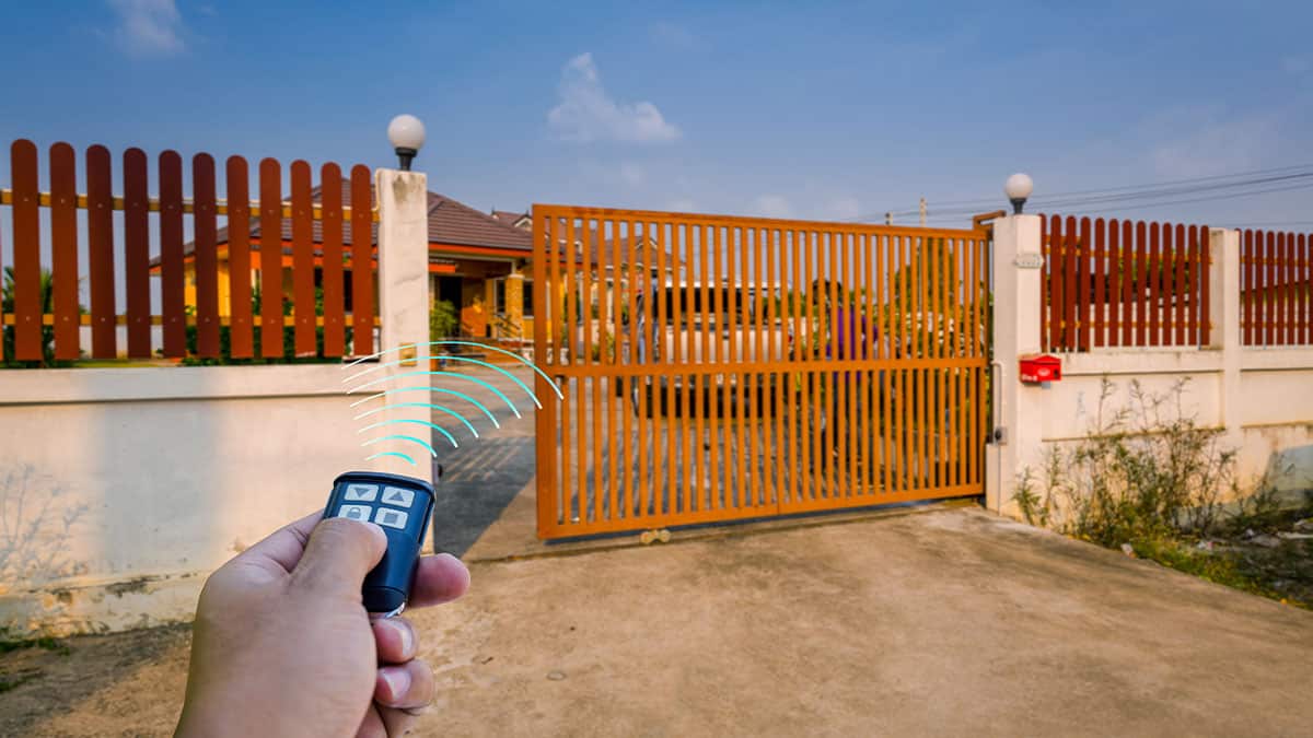 A Person Opens A Gate Using A Remote Controller